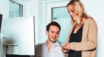 Two team members excited while collaborating at a screen